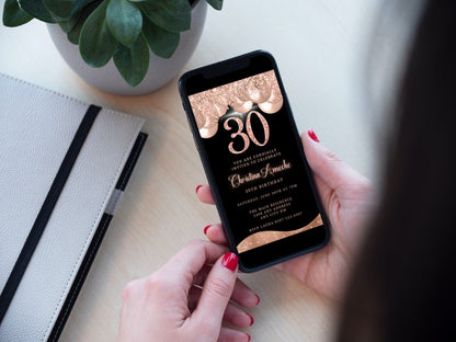 Person holding a phone displaying a customizable Rose Gold Balloons Glitter 30th Birthday Evite from URCordiallyInvited, ready for editing and digital sharing via Canva.