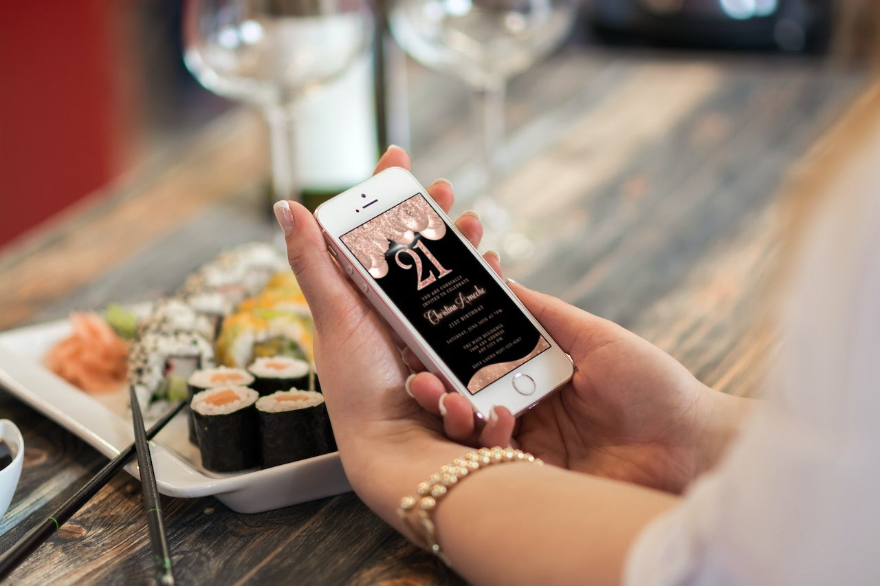 Person holding a smartphone displaying a customizable Digital Rose Gold Balloons Glitter 21st Birthday Evite from URCordiallyInvited.