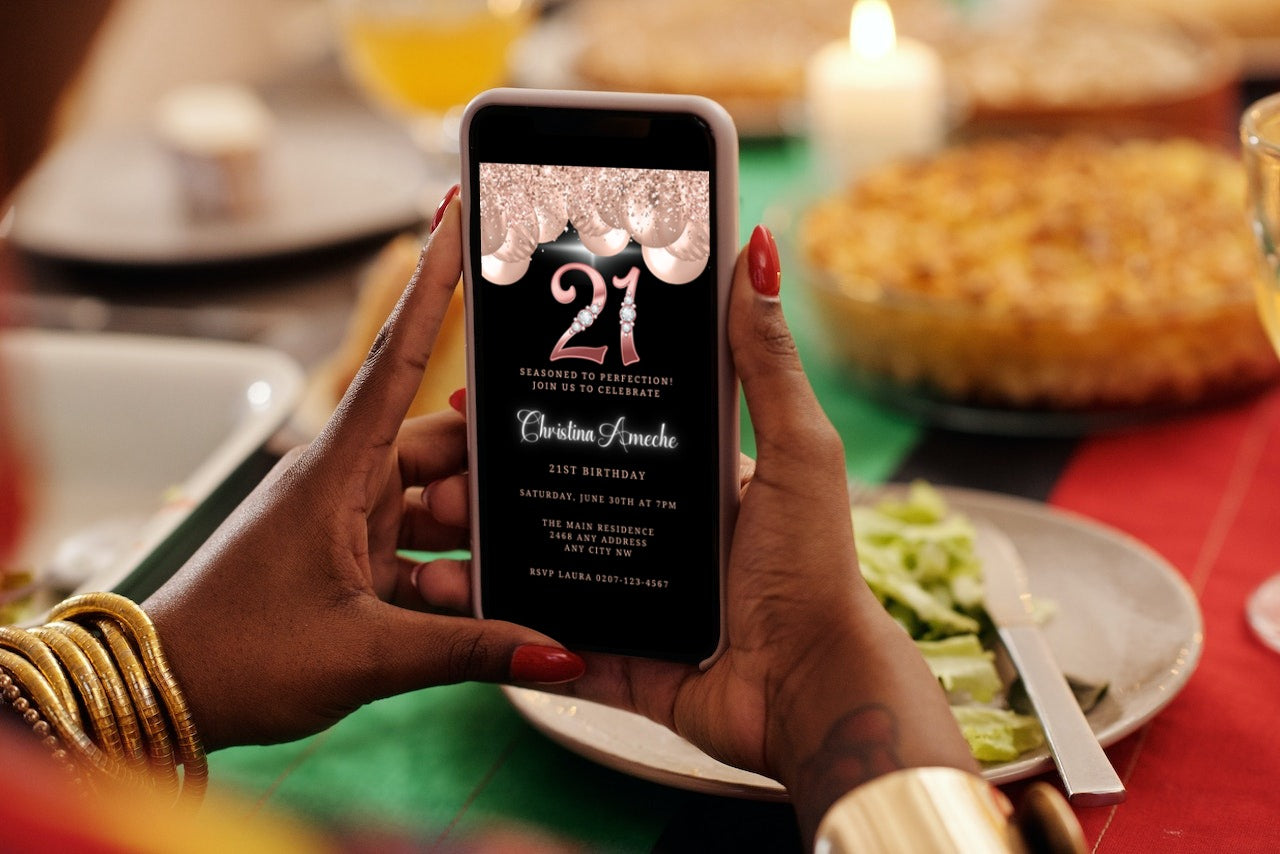 Person holding a smartphone displaying a customizable Rose Gold Balloons Diamond Studs 21st Birthday Evite template from URCordiallyInvited.