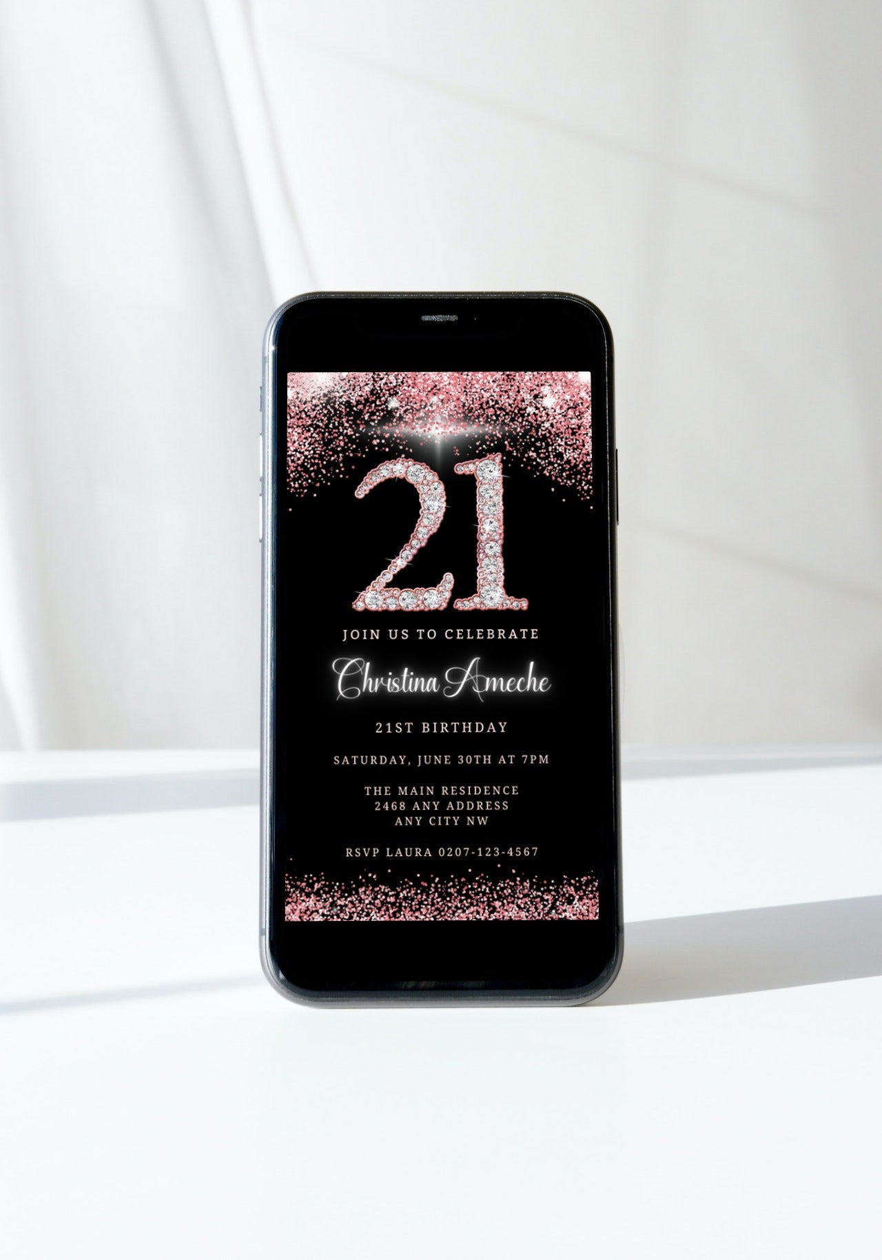 Cell phone displaying a customizable 21st birthday evite template with rose gold glitter and diamond design.