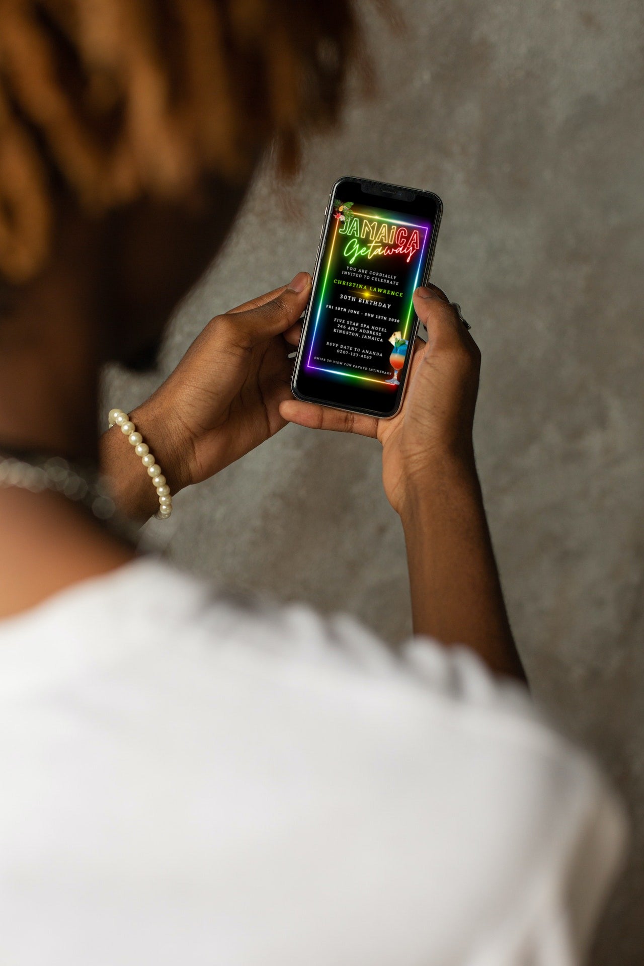 Person holding a smartphone displaying the Jamaica Colourful Neon | Getaway Party Evite, a customizable digital invitation template available for editing on Canva.