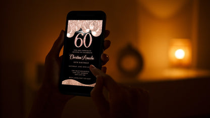 Person holding a smartphone displaying the customizable Rose Gold Balloons Glitter 60th Birthday Evite, ready for editing and sharing via Canva.