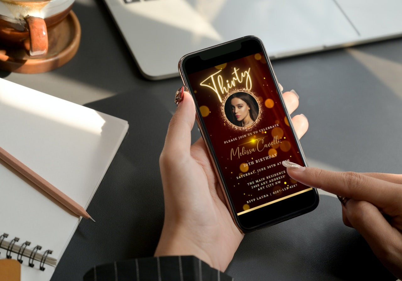 Person holding a smartphone displaying a customizable Gold Black Maroon Glitter 30th Birthday Video Invite template from URCordiallyInvited.