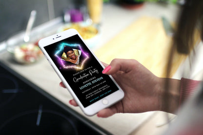 A hand holds a smartphone displaying the Neon Diamond Frame Graduation Party Invitation, featuring a customizable black and gold design for digital sharing.