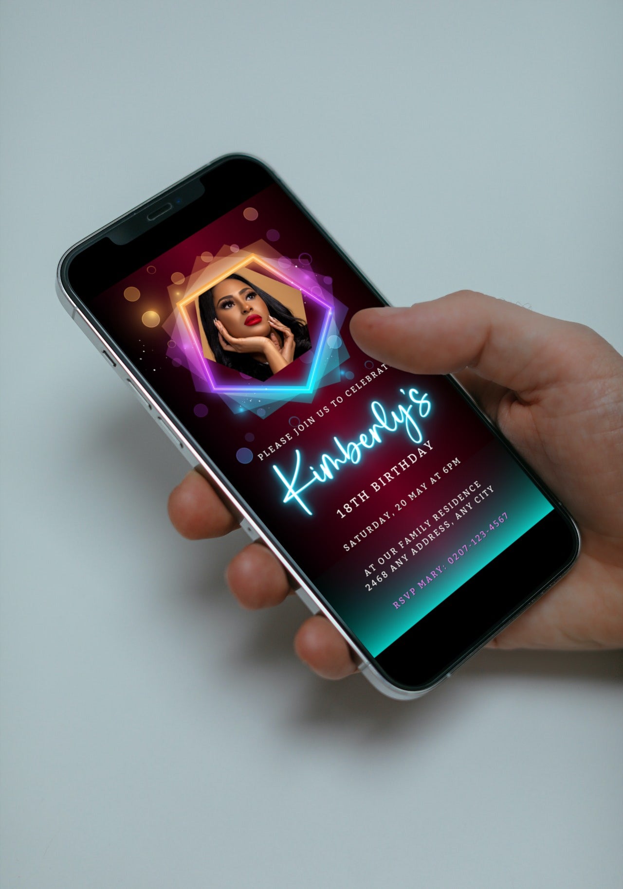 Hand holding smartphone displaying customizable Birthday Party Evite template with neon maroon and teal accents, featuring a photo and editable text.