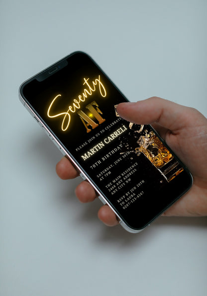 Hand holding a smartphone displaying the customizable Black Gold Neon Cube Splash | 70AF Birthday Evite available for editing via Canva.