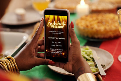 Person holding a phone displaying a customizable Gold Glitter Disco Bachelorette Video Invitation template.