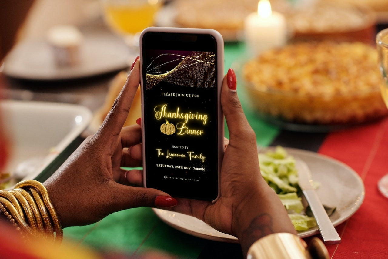 Person holding a phone with Gold Pumpkin Motion Glitter Thanksgiving Dinner Video Invite displayed on screen.