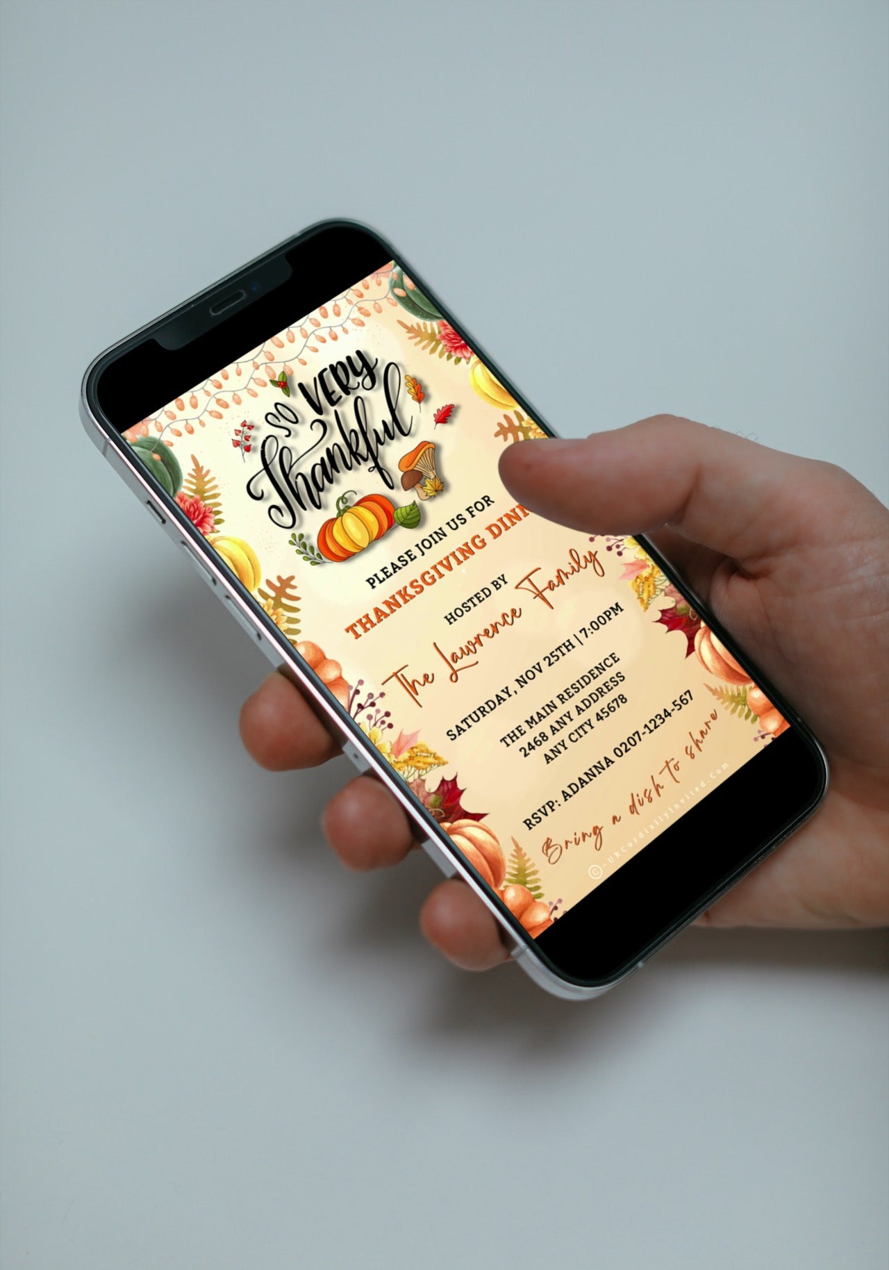Hand holding a phone displaying a Beige Gold Fruitful Sparkle Thanksgiving Dinner Video Invite template with pumpkins and leaves.