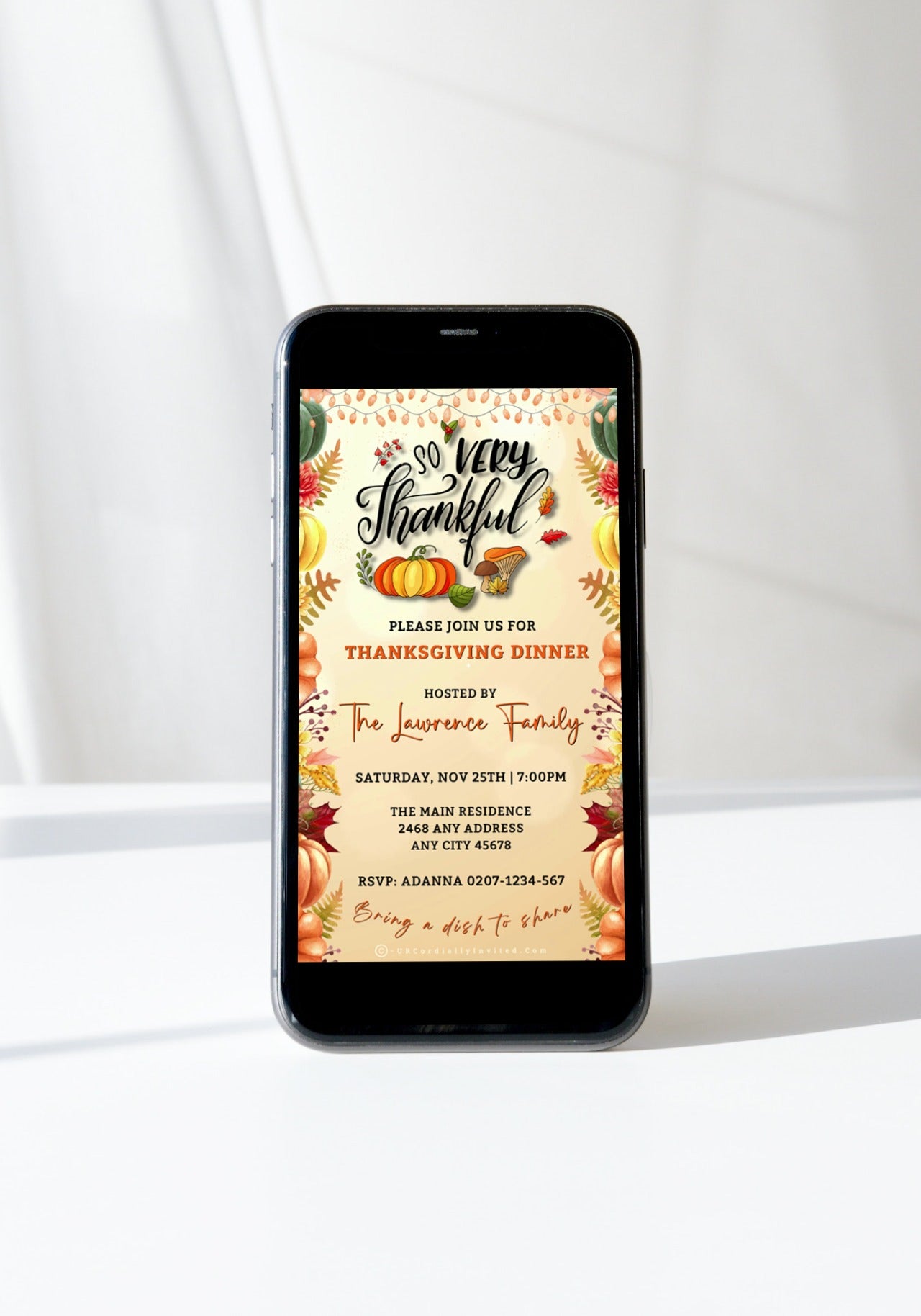 Beige Gold Fruitful Sparkle | Thanksgiving Dinner Video Invite displayed on a mobile phone screen with festive pumpkins and leaves in the background.