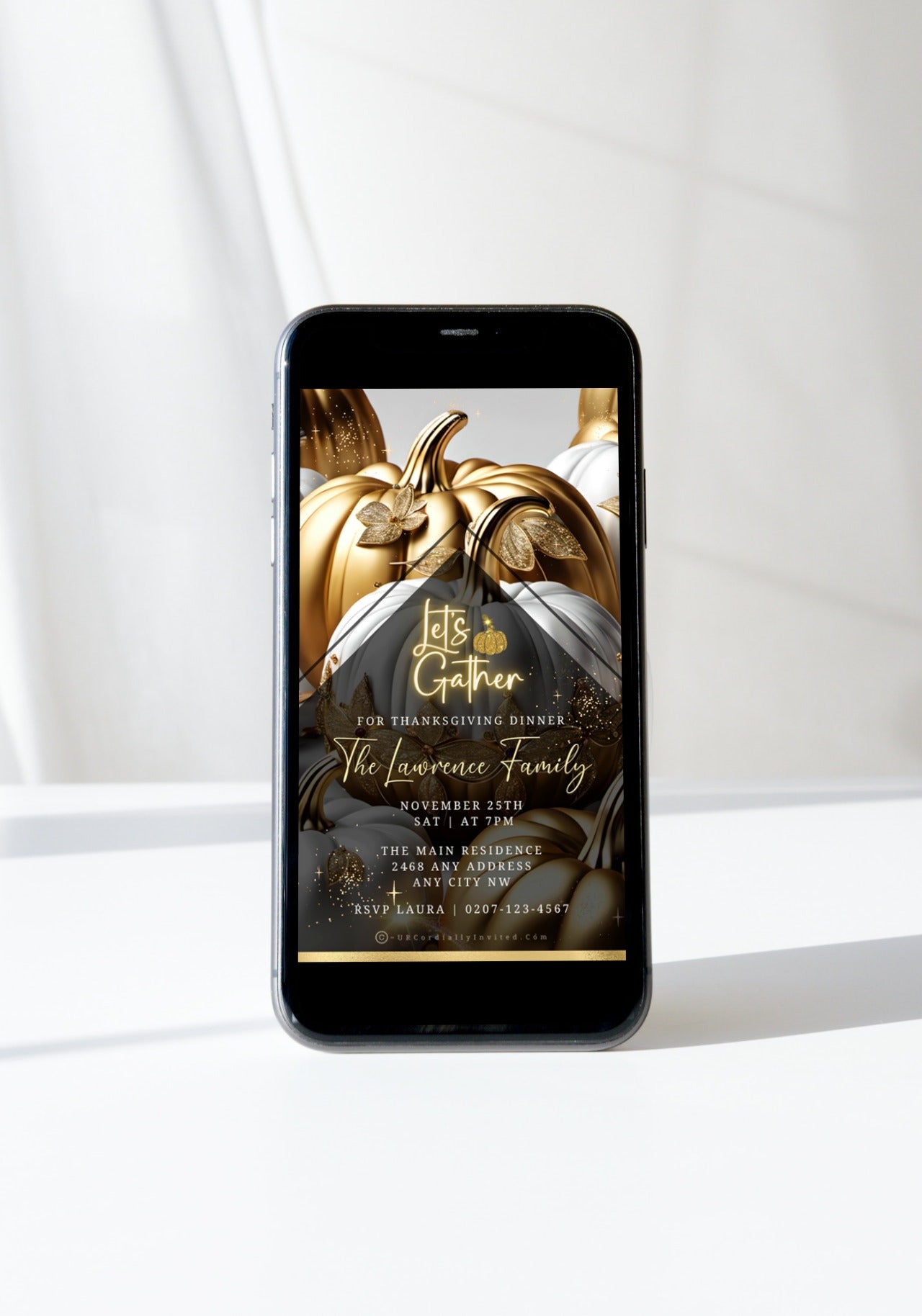 Smartphone displaying Gold Neon White Pumpkin Thanksgiving Dinner Video Invite with elegant script and pumpkin artwork, emphasizing sophisticated digital invitation customization through URCordiallyInvited.
