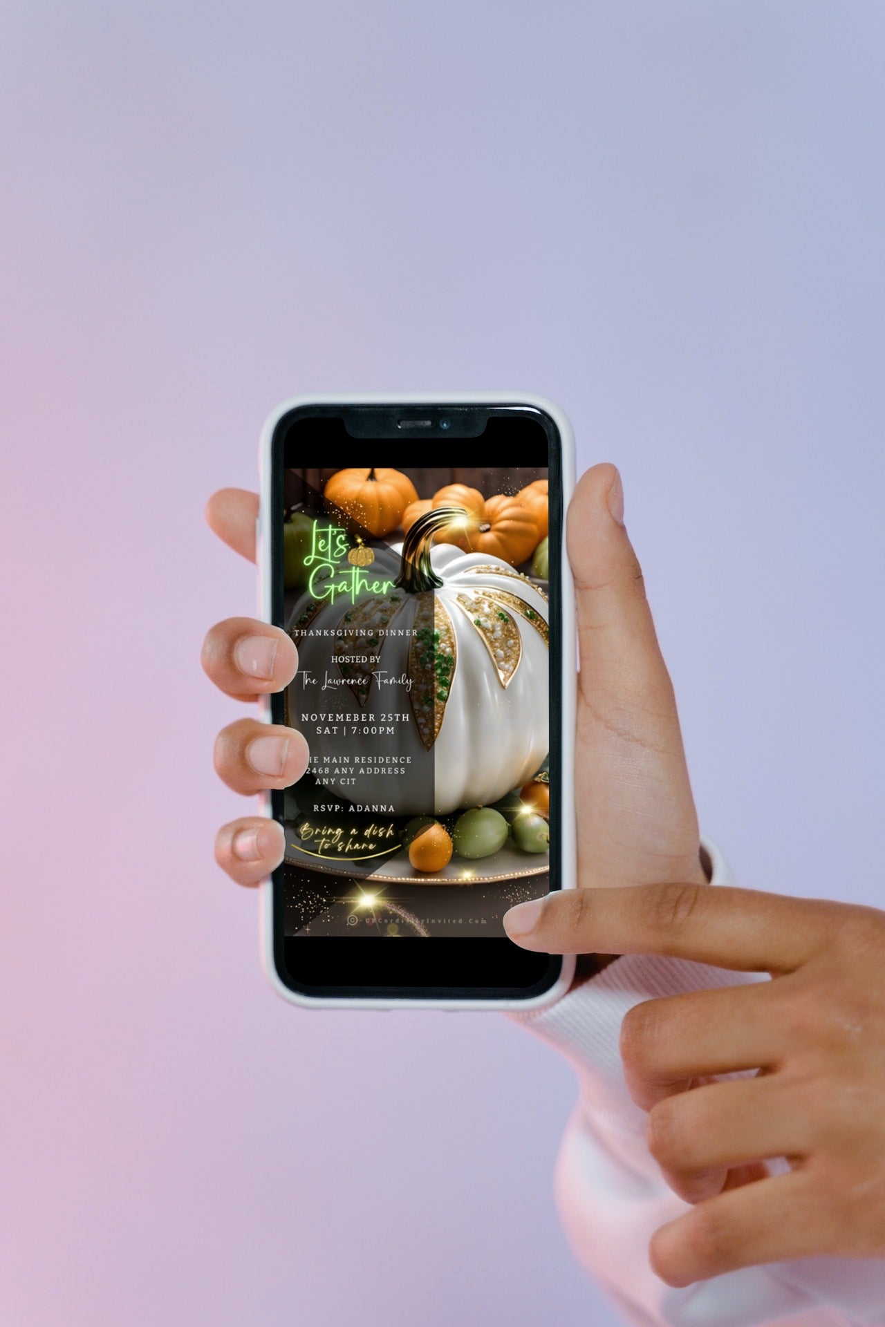 Hand holding a cell phone displaying a customizable White Fruitful Platter Glitter Pumpkin Thanksgiving Dinner Video Invite template.