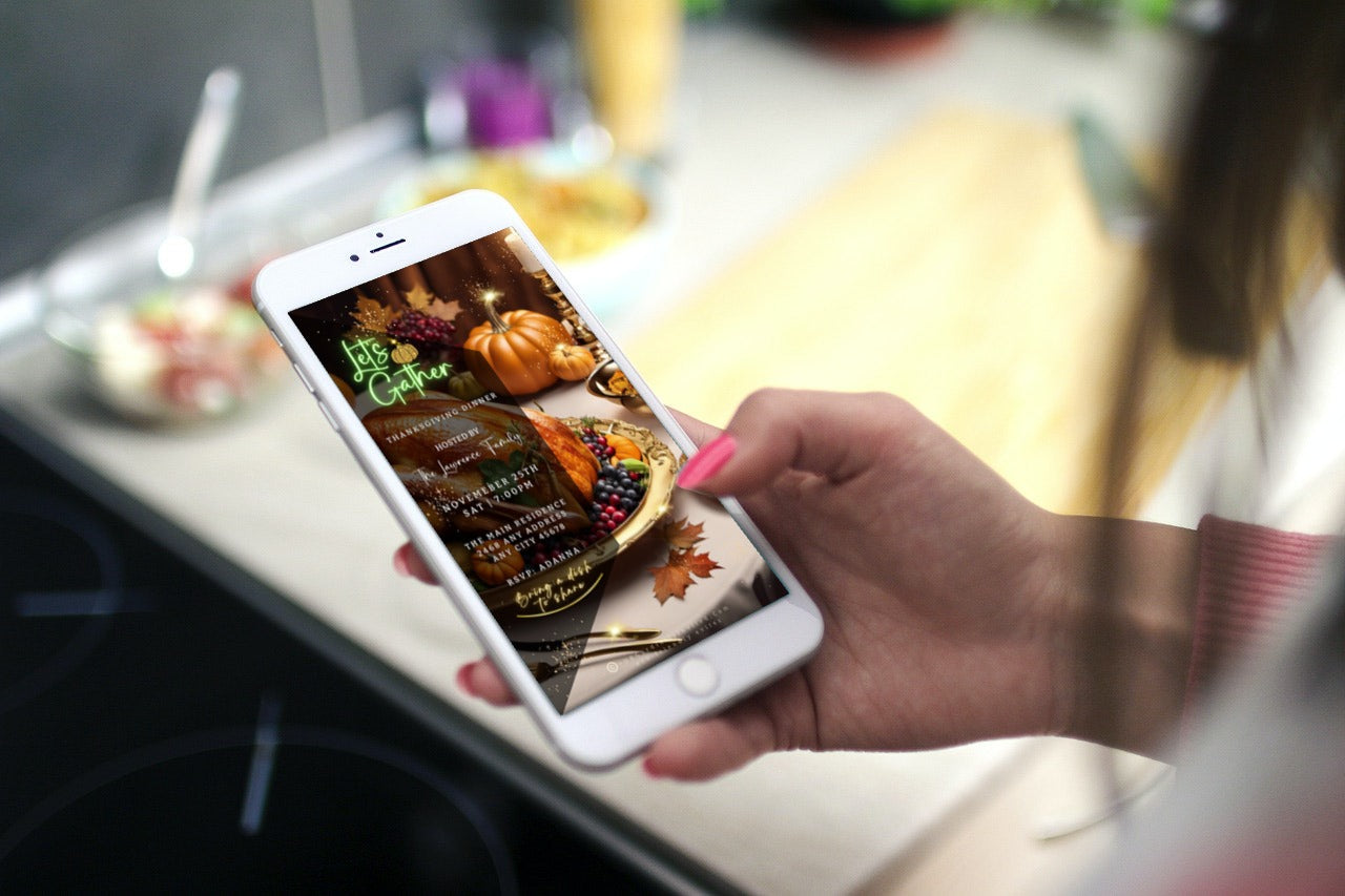 Hand holding a smartphone displaying the Gold Fruitful Platter Pumpkins | Thanksgiving Dinner Video Invite with a festive Thanksgiving graphic and event details in a kitchen setting.