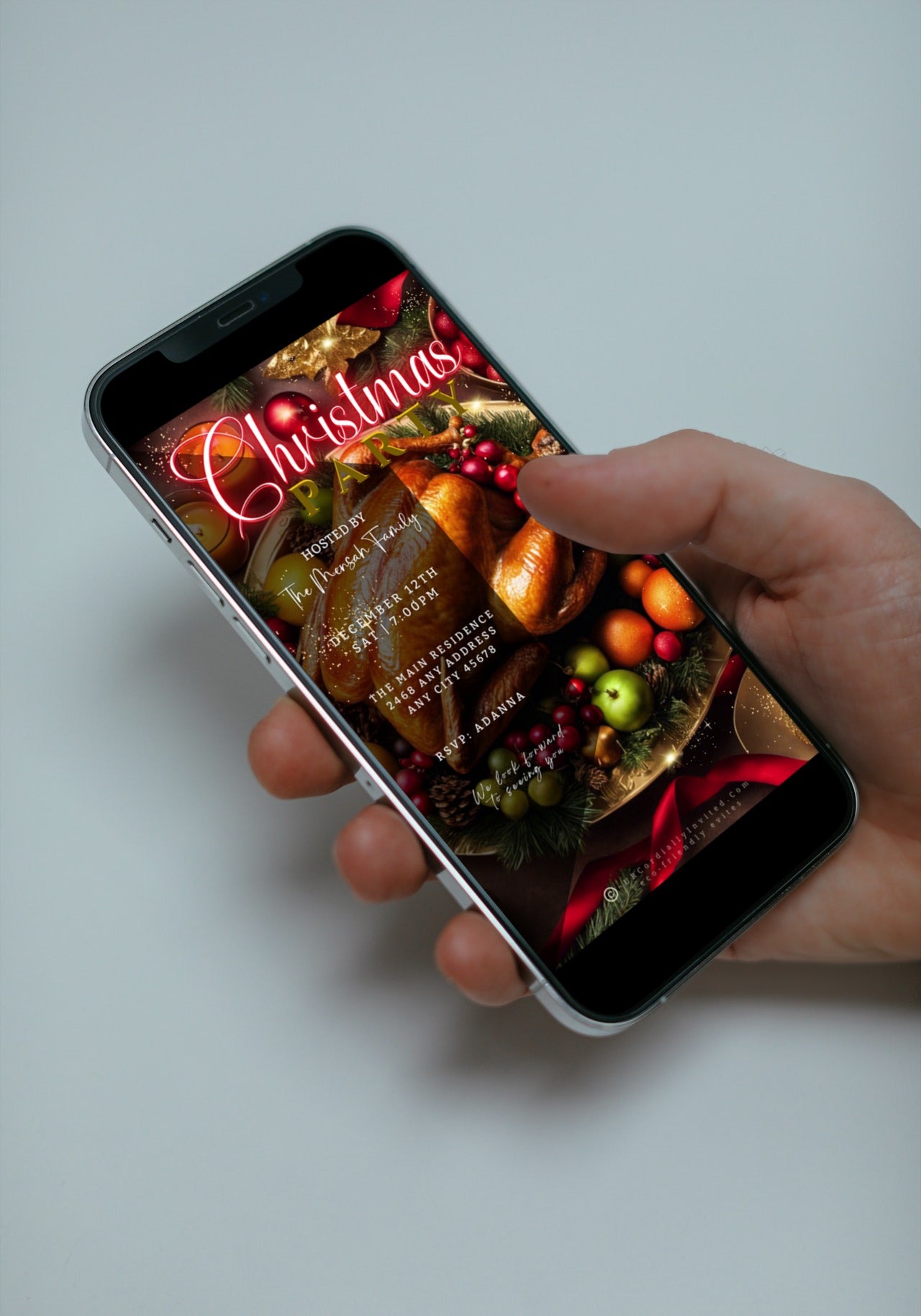 Person holding a smartphone displaying a Red Neon Festive Food Platter Christmas Video Invitation, customizable via Canva for digital sharing.