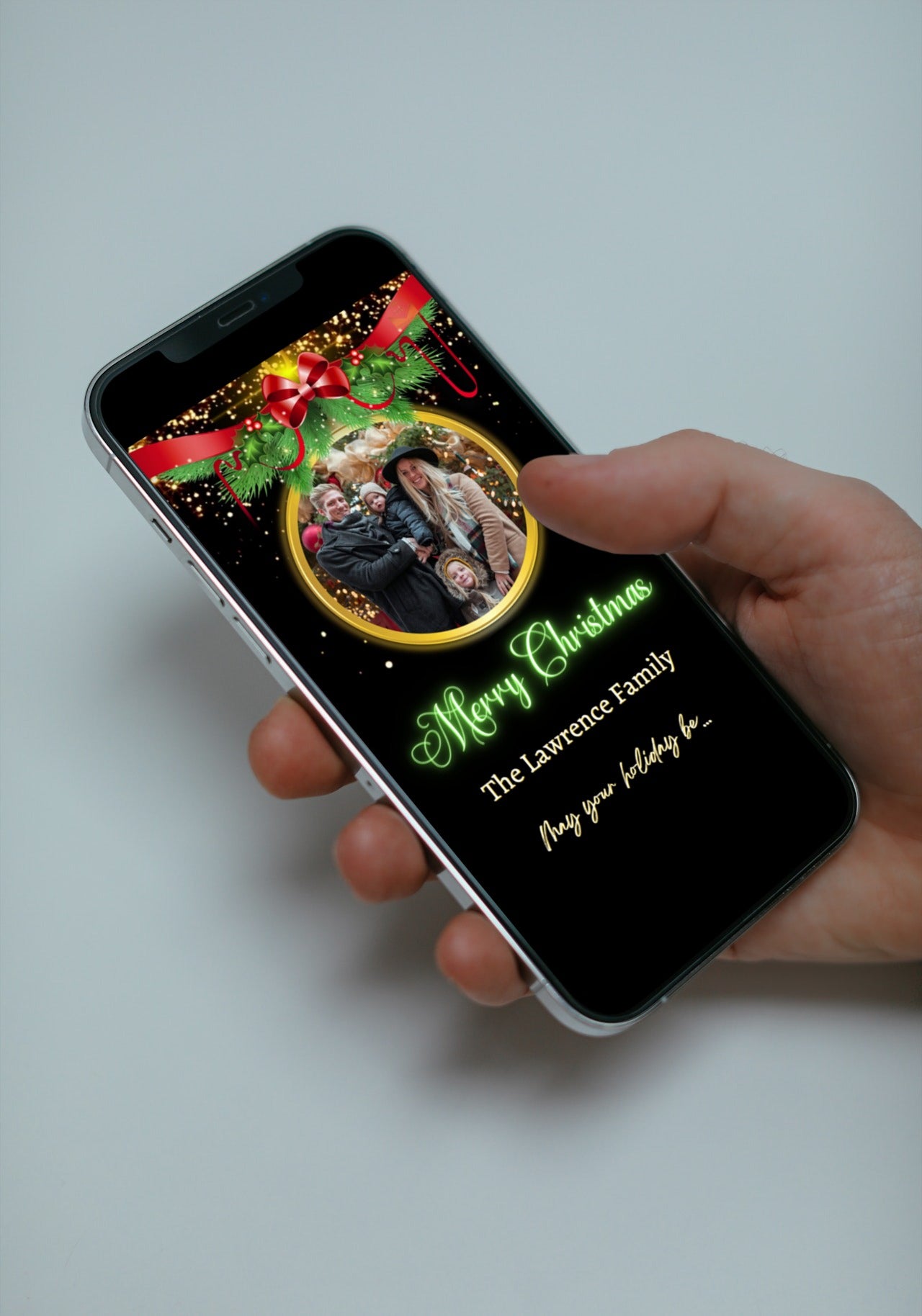 Hand holding a smartphone displaying a customizable Neon Green Oval Ornament Christmas Video Ecard, editable via Canva for personal events and instant digital sharing.