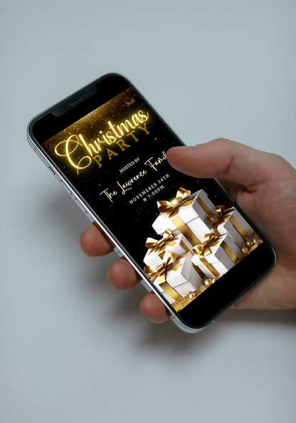 Hand holding a smartphone displaying a customizable Christmas video invitation with white gold leaves and presents, designed for editing and sharing via Canva.