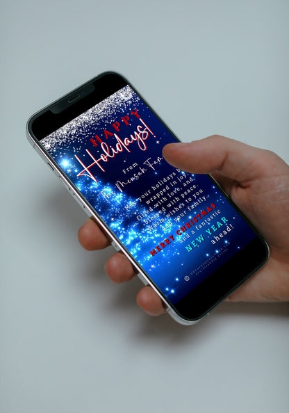 Hand holding a smartphone displaying the Editable Digital Blue Crystal Silver | Happy Holidays Video Greeting Ecard template from URCordiallyInvited.