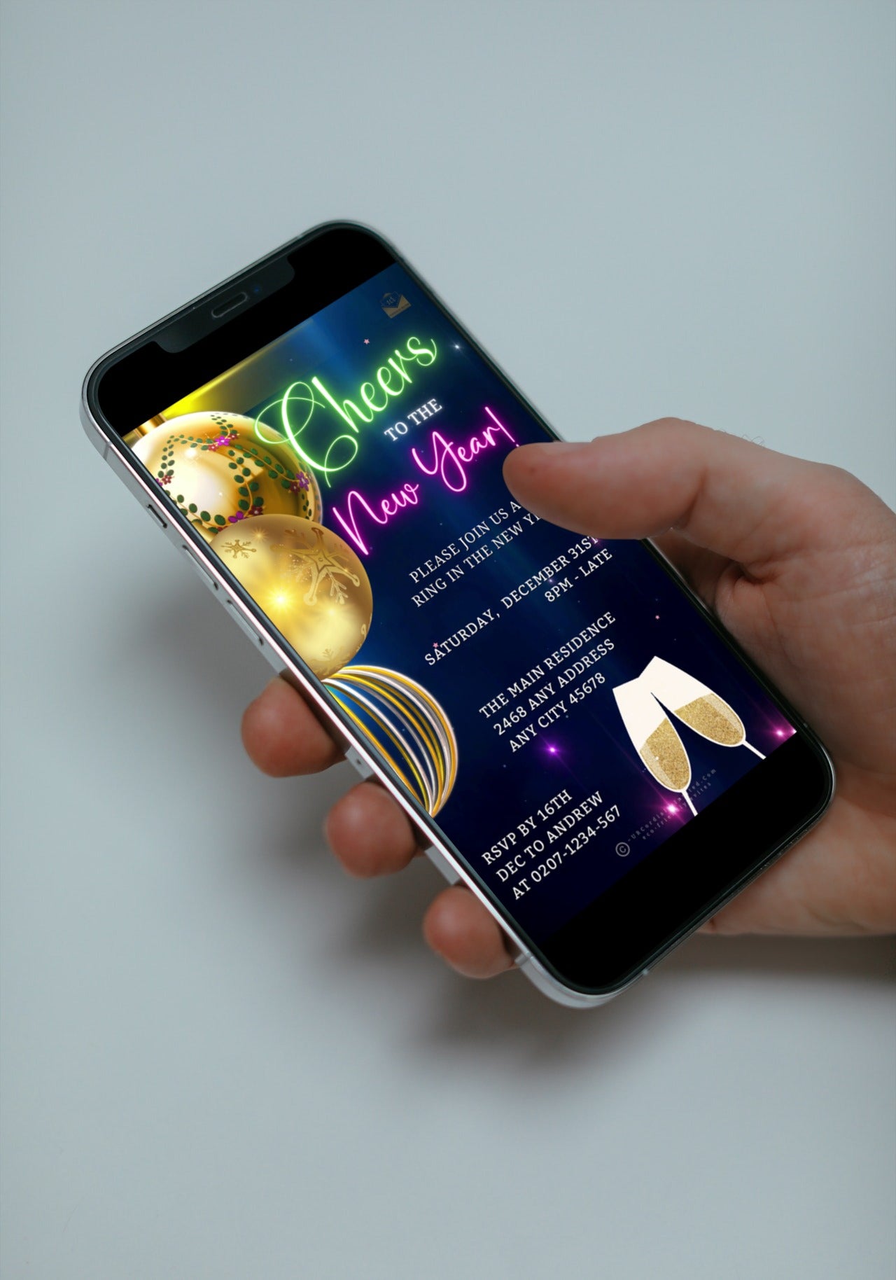Hand holding a smartphone displaying an Editable Digital Ornamental Colourful Champagne New Year's Eve Party Video Invitation.