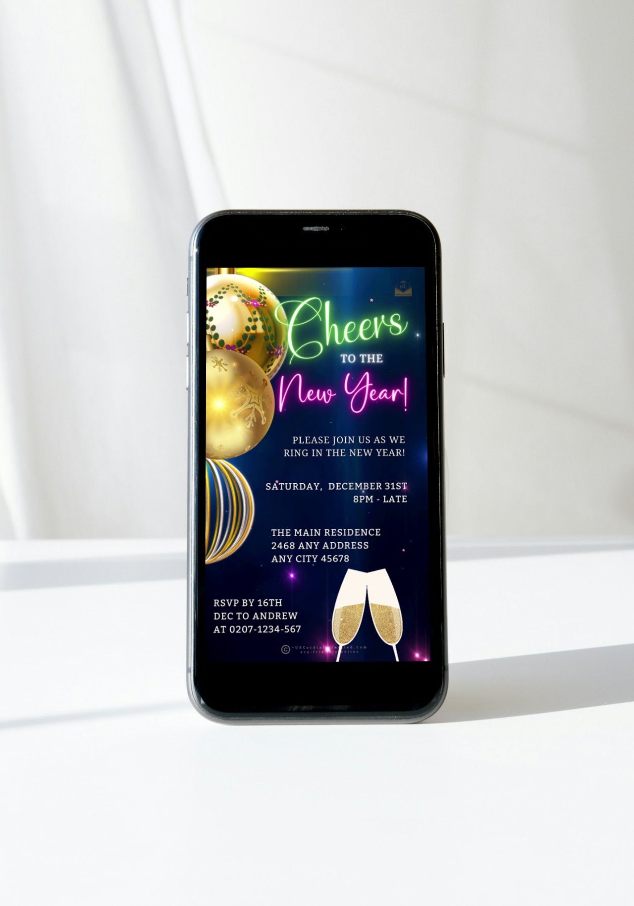 Smartphone displaying Ornamental Colourful Champagne New Year's Eve Party Video Invitation, with champagne glasses in the background. Editable, customizable via Canva for digital sharing.