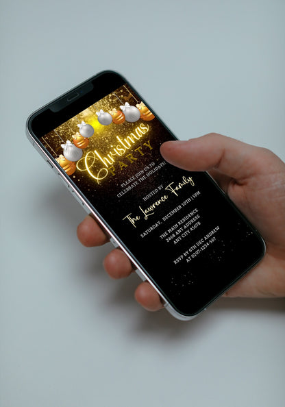 Hand holding a smartphone displaying a Snowy Gold White Ornaments Glitter Christmas Party Video Invite template for customization.