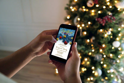 Person holding a phone displaying the Snowy Elegance Blue Leaves Christmas Party Video Invite with a Christmas tree in the background.
