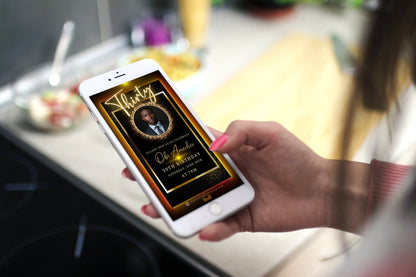 Hand holding a phone displaying the Black & Gold 70th Birthday Video Invitation with an elegant oval photo frame, designed for customization via Canva.