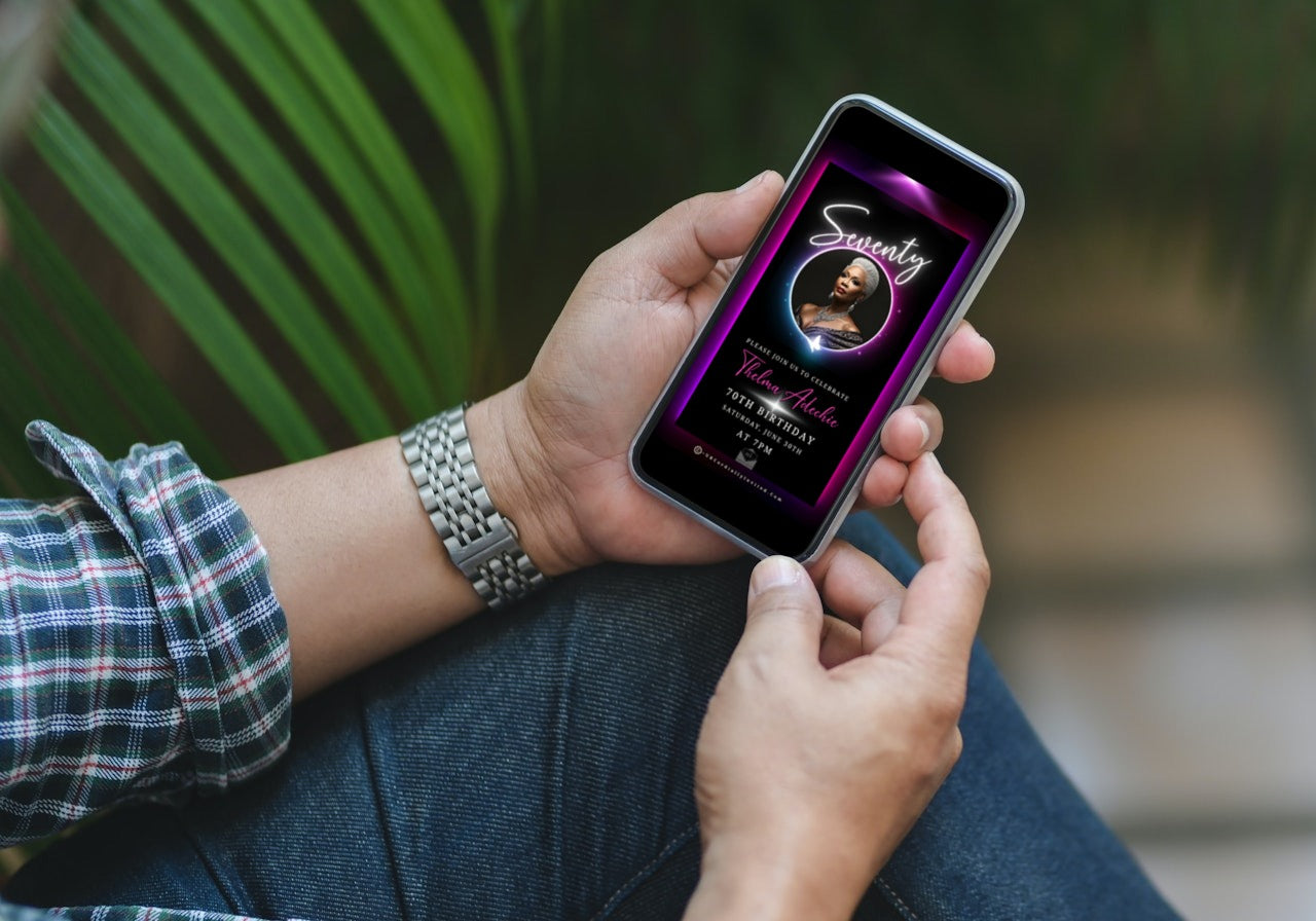 Person holding a phone displaying the 60th Birthday Video Invitation with a pink and purple oval photo frame, designed for elegant milestone celebrations.